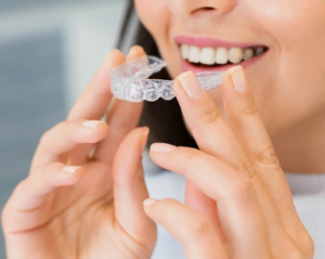 a person holding a clear dental aligners