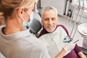 a person sitting in a chair with a dentist in the background