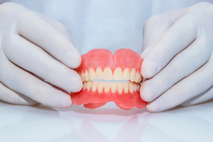 a dentist holding the dentures